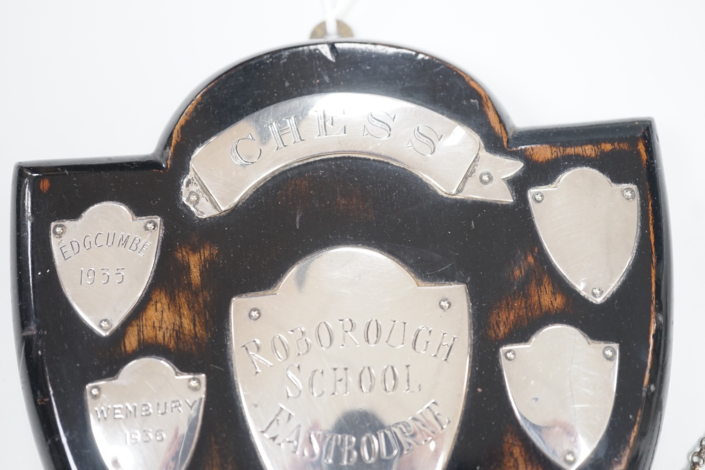 A small 1930's silver christening mug, two 19th century silver decanters labels 'Claret' and 'Marsala' and a white metal mounted polished wood shield 'Roborough School, Eastbourne Chess' and a Victorian silver oval musta